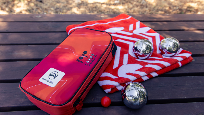 image printemps présentant une serviette de plage et un jeu de pétanque.